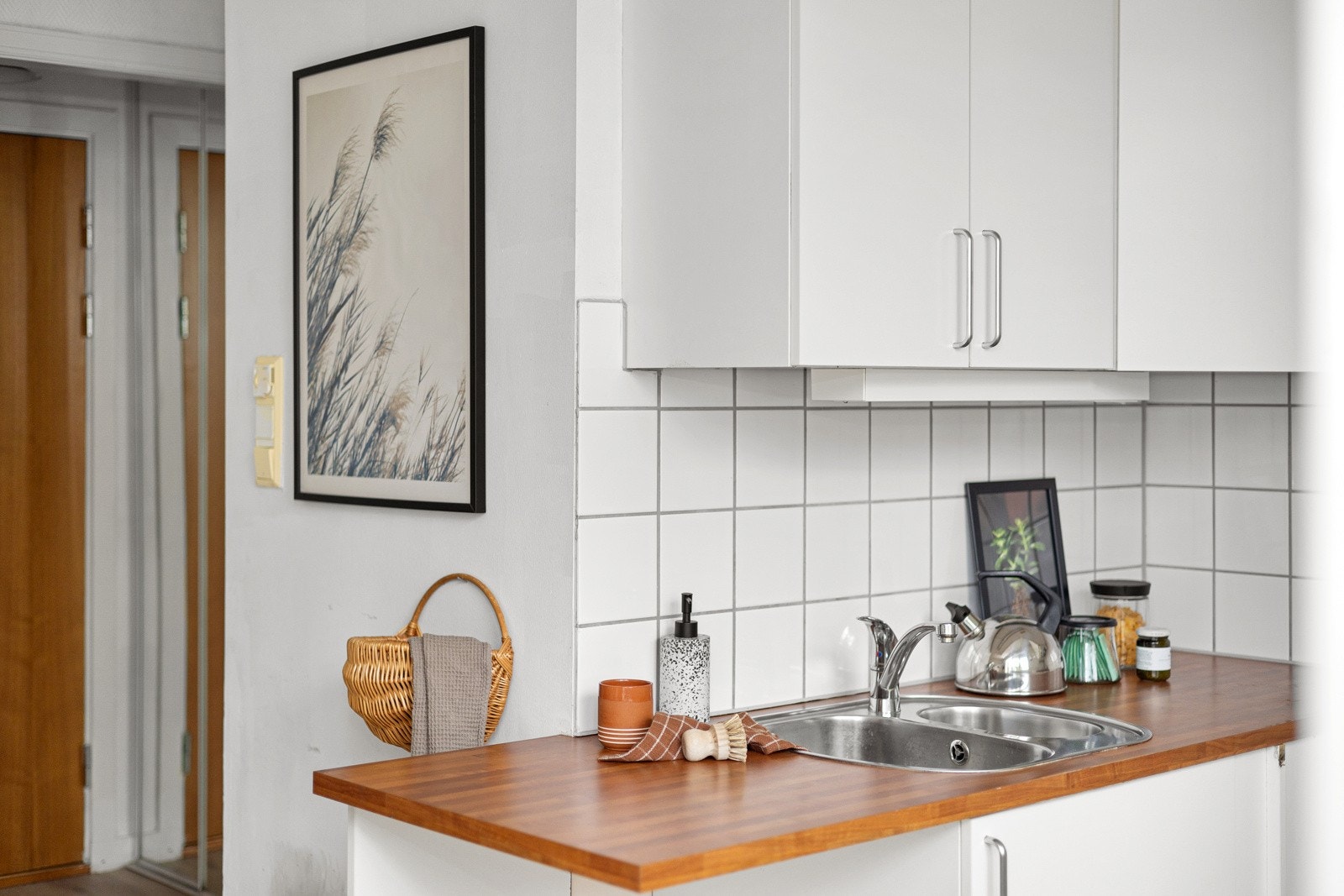 Lys kjøkkeninnredning med glatte fronter og laminert benkeplate med nedfelt oppvaskkum. Galleribilde