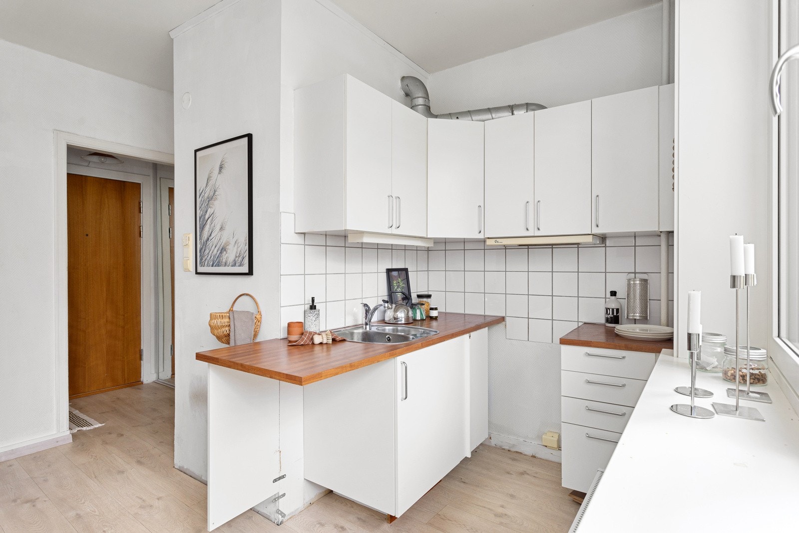 Praktisk med fliser i benkeryggen og belysning under overskap. Plass til mindre kjøleskap under benkeplaten og komfyr under ventilator koblet til avtrekk. Galleribilde