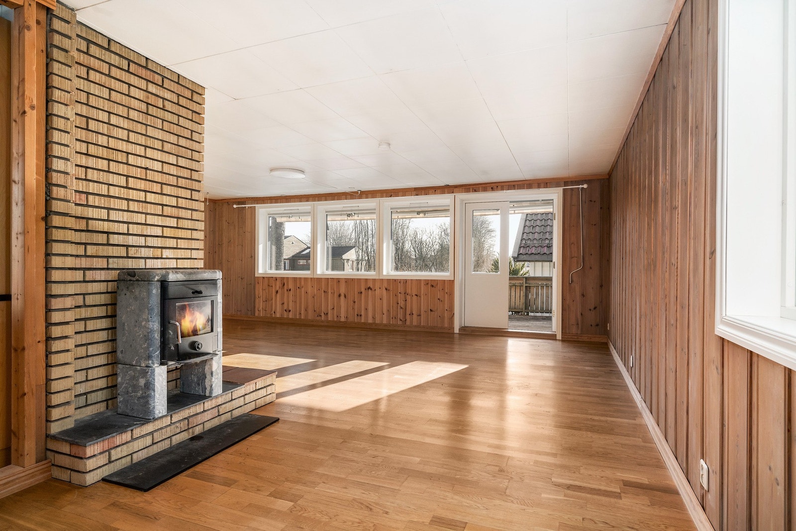 Stor vinkelstue med generøse vindusflater og utgang til hage og terrasse. Galleribilde