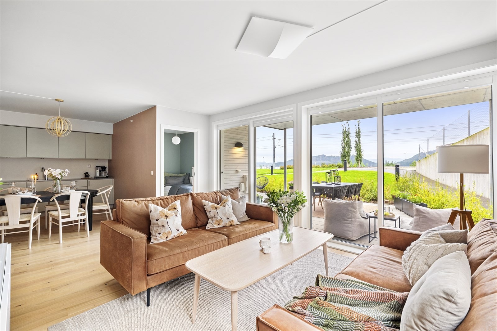 Leiligheten har en åpen stue- og kjøkkenløsning med enstavs parkettgulv og slette vegger i moderne fargetoner Galleribilde