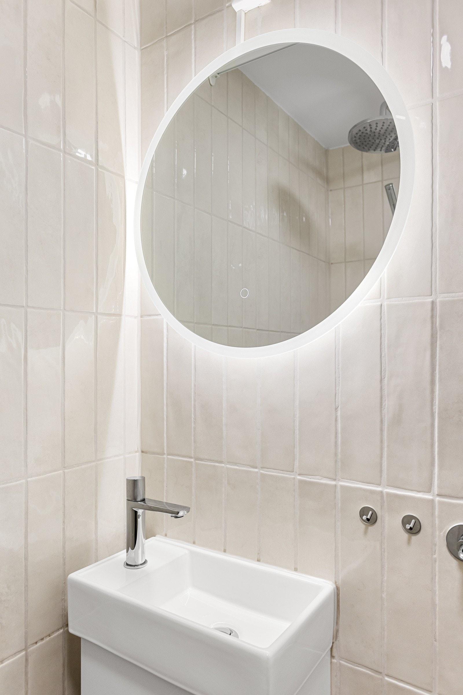 Moderne baderomsinnredning fra 2023 med skap og servant, speil med innebygget belysning. Galleribilde