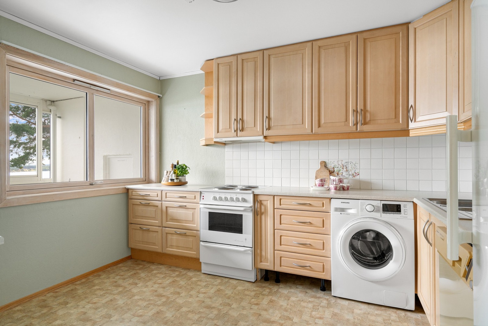 Kjøkkenet har innredning med mye skapplass Galleribilde