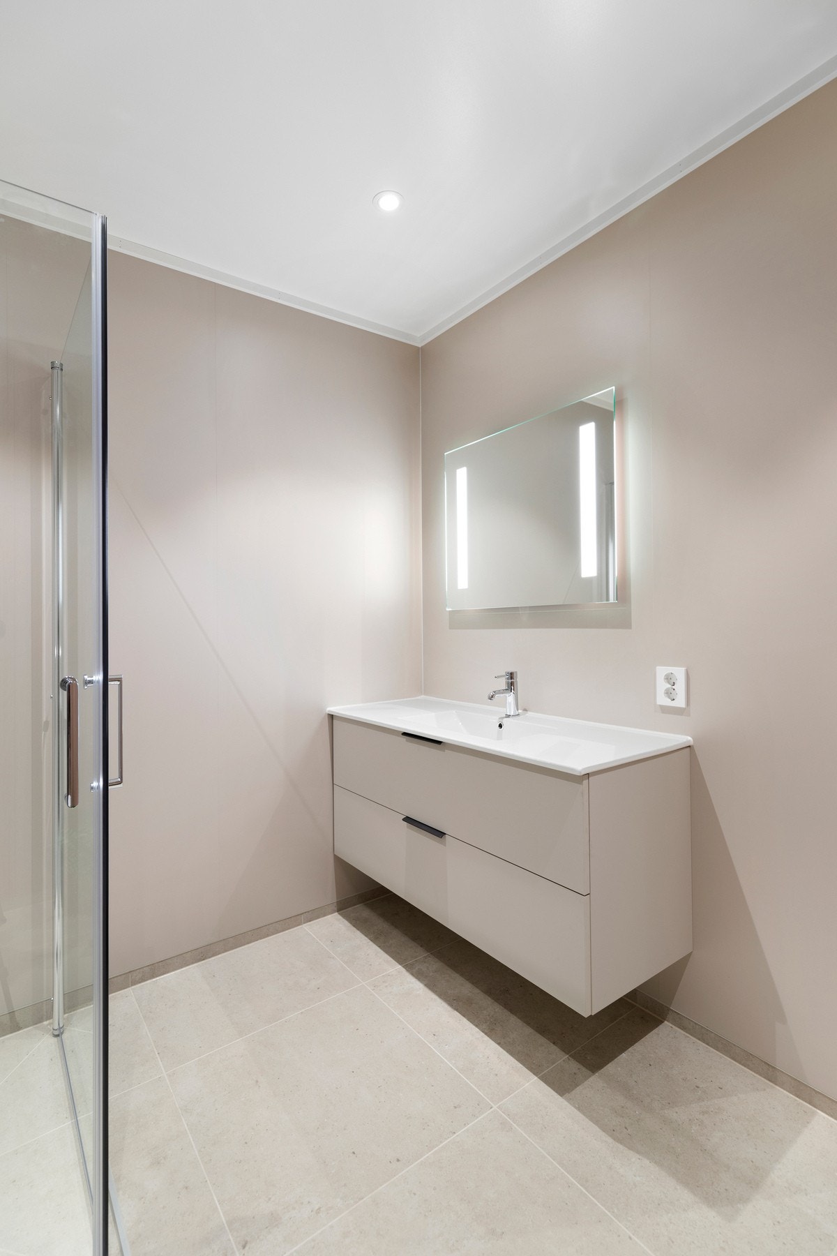 baderomsinnredning med helstøpt servantplate og speil med integrert belysning Galleribilde