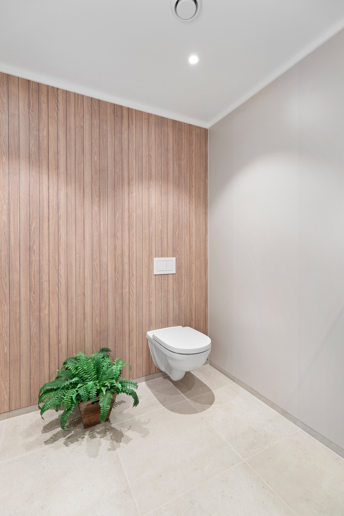 Det er montert veggholdt toalett, dusjnisje med glassdører, og Galleribilde