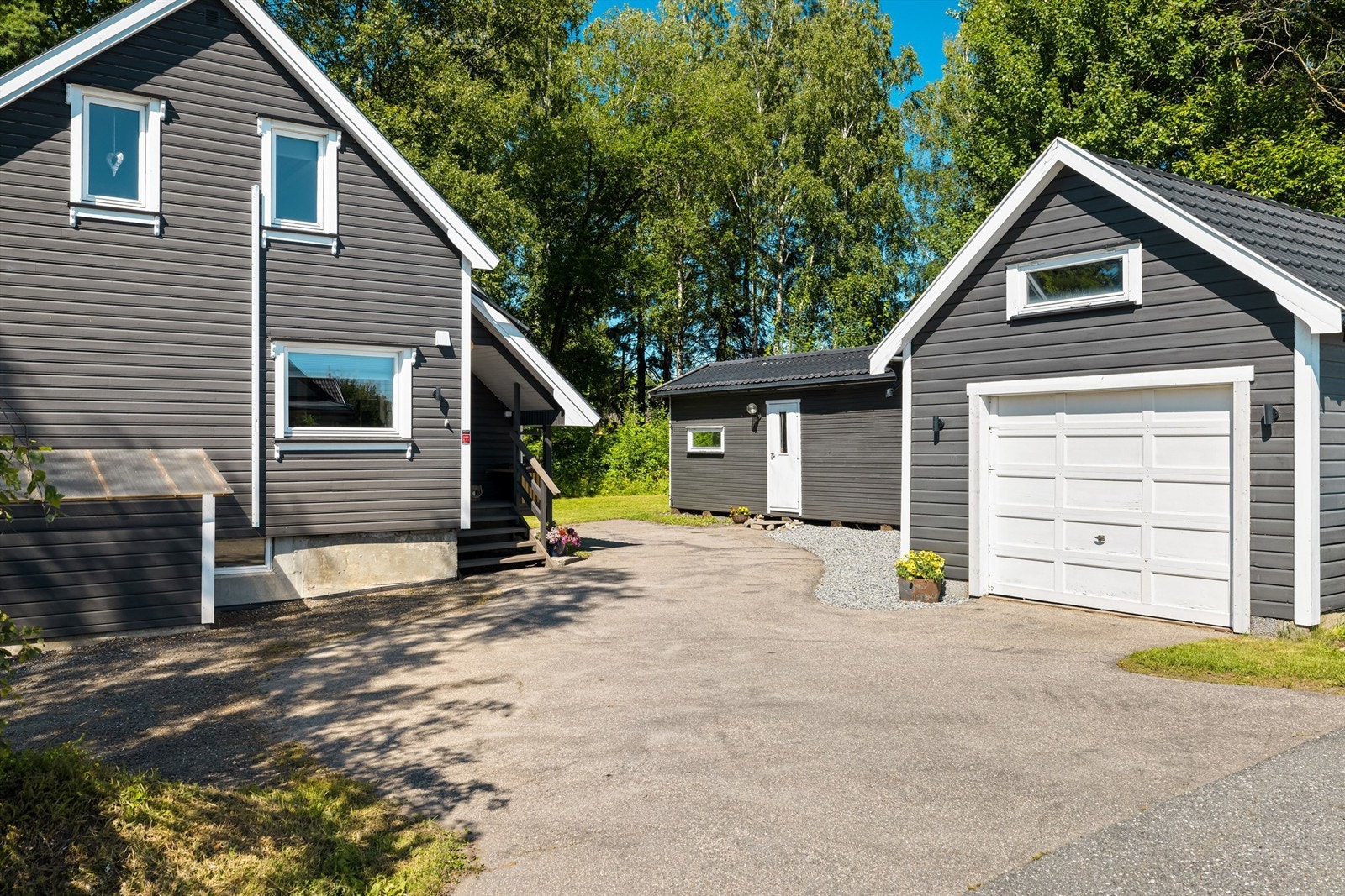 Både garasje og uthus er oppført omkring gårdsplassen, på østre side av tomten. Galleribilde