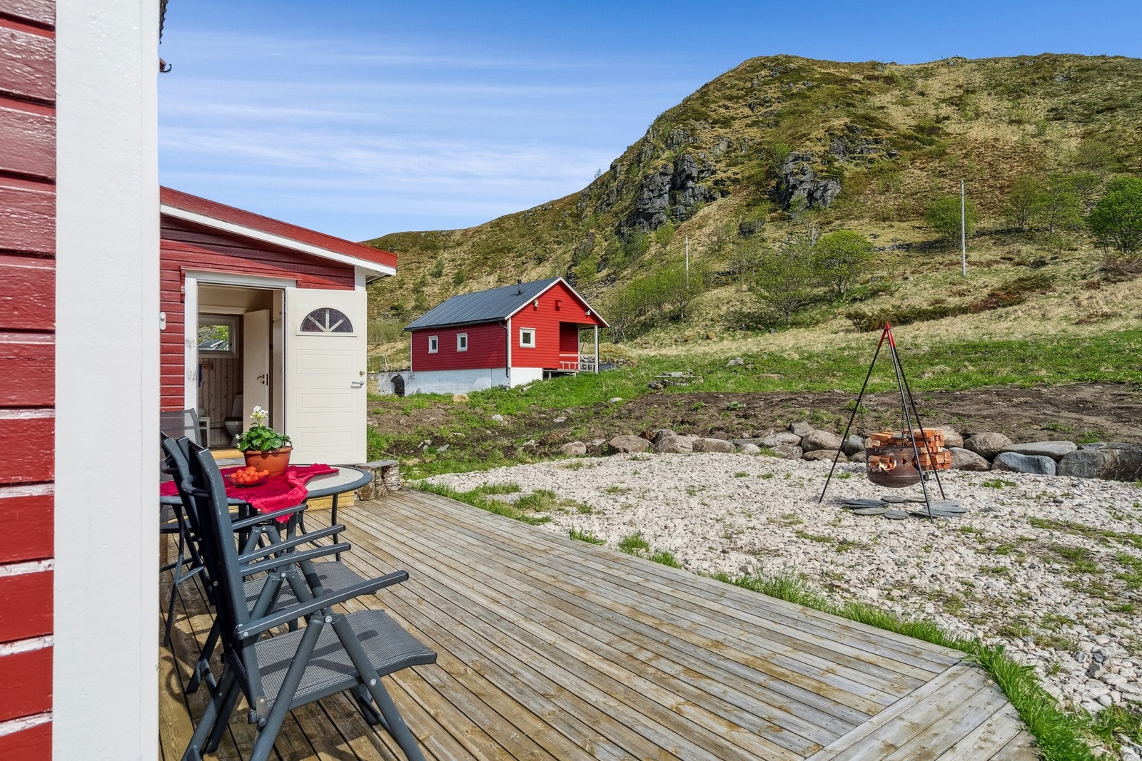 Her kan du fyre i bålpannen på terrassen. På bildet ser du også tidligere fjøs som følger med eiendommen. Galleribilde
