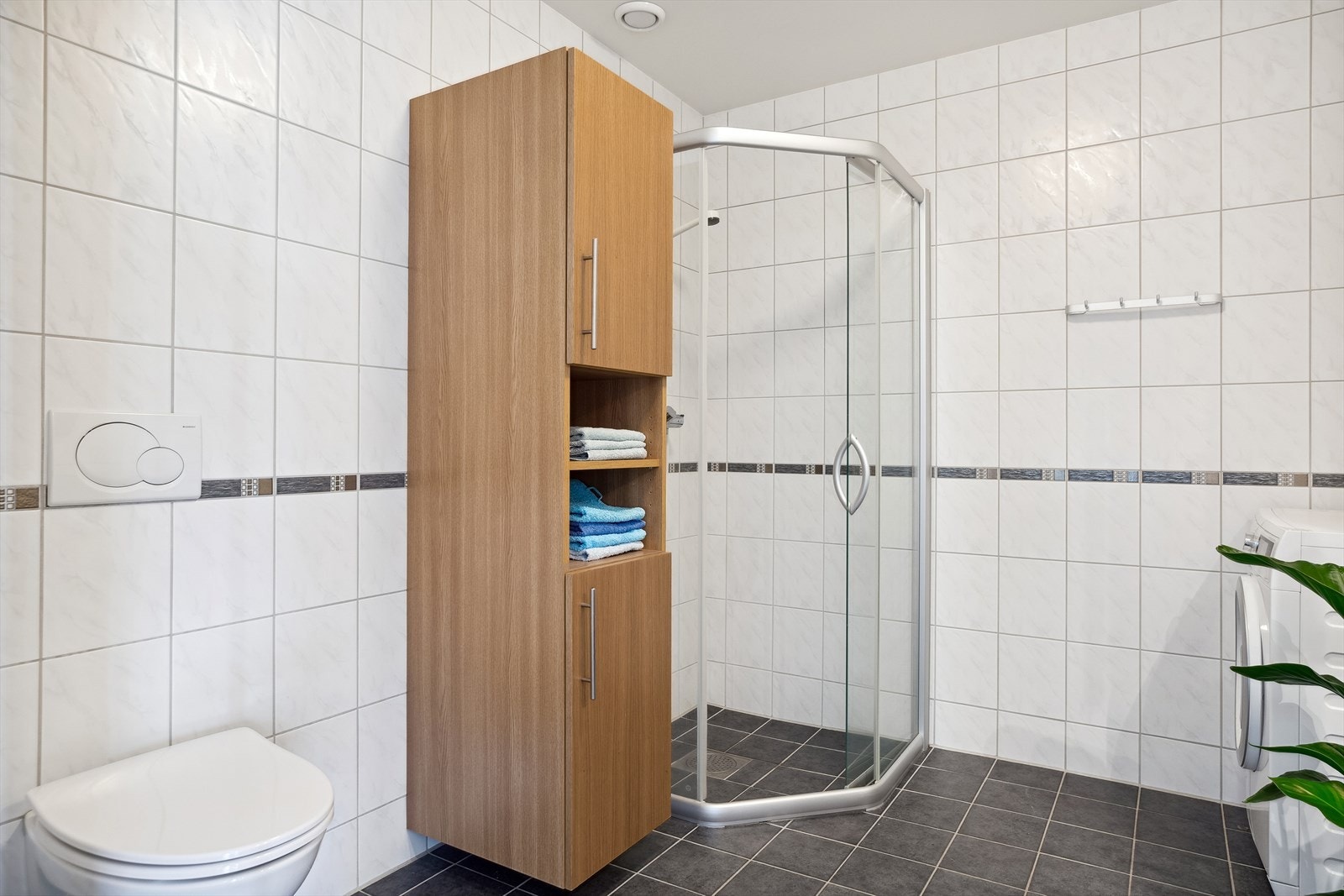 På badet er det vegghengt toalett, dusjhjørne og opplegg for vaskemaskin. Galleribilde