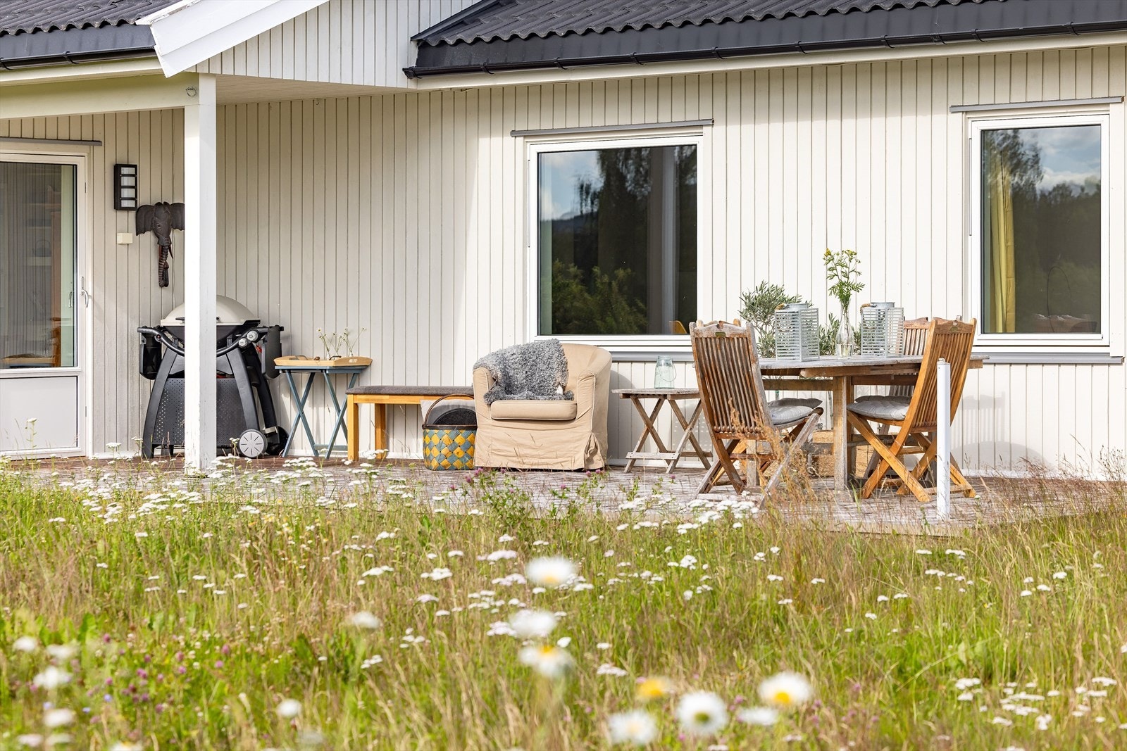 Terrassen er delvis overbygget. Det er montert utebelysning og stikkontakt på vegg. Galleribilde