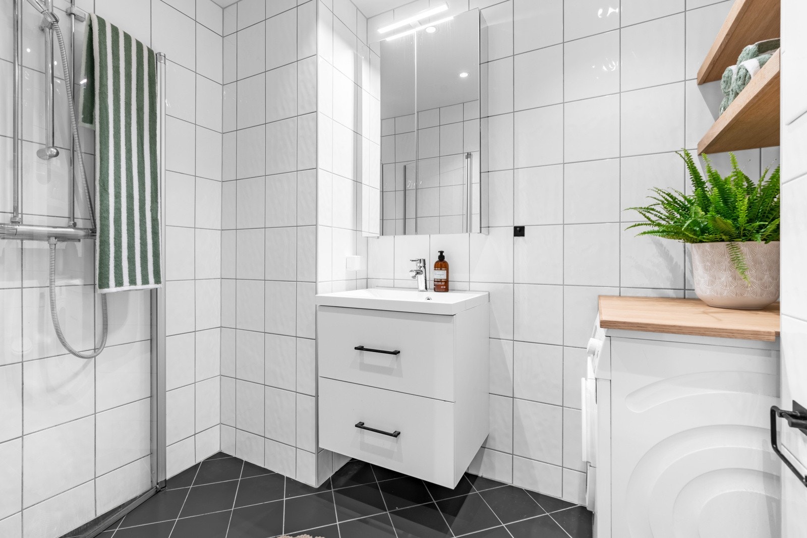 Pent baderom med varmekabler i gulv, opplegg for vaskemaskin og downlights i taket Galleribilde