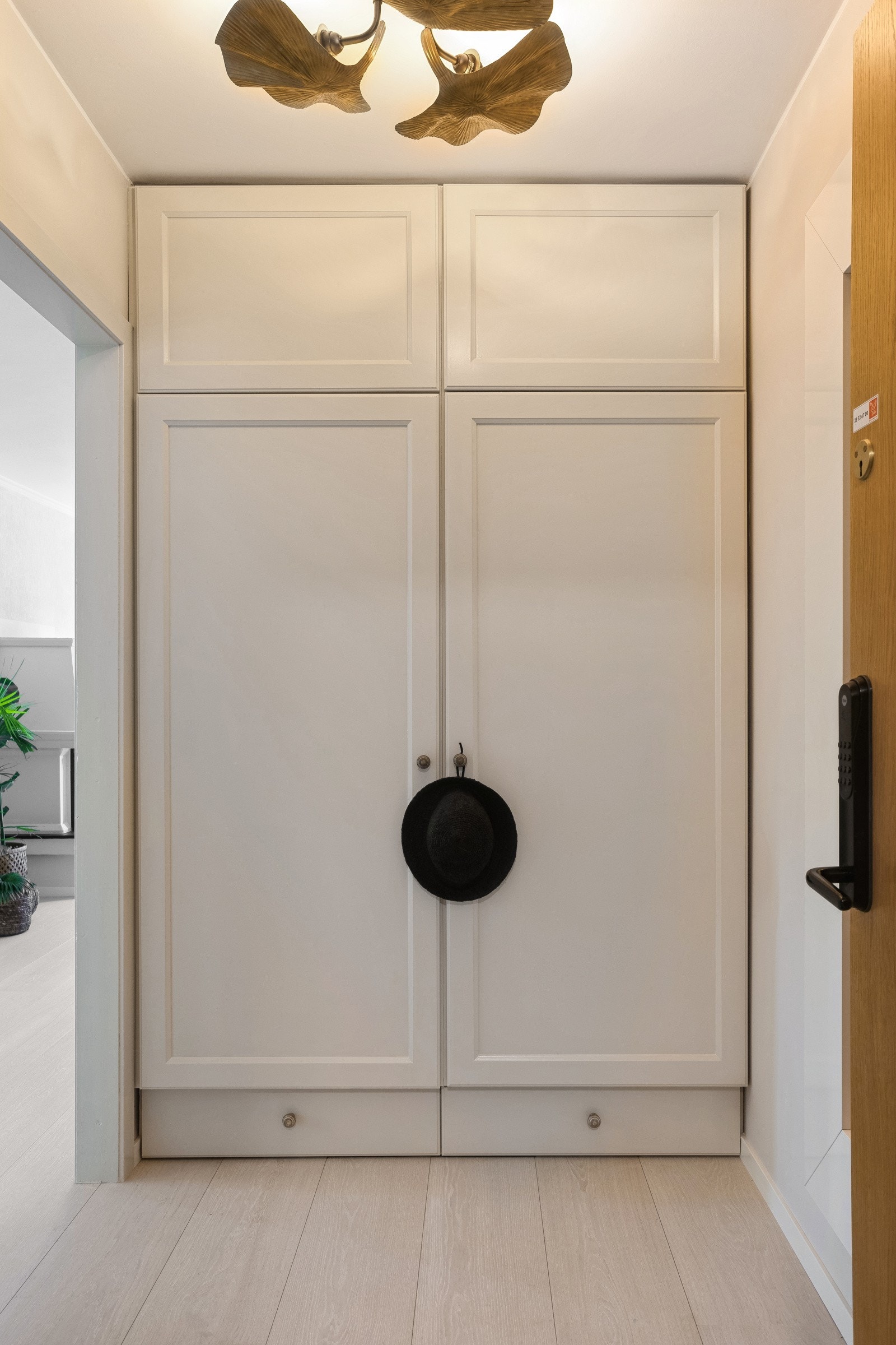 Lys og romslig entré med moderne plassbygd garderobeskap med hyller, klesoppheng og sokkelskuffer. Galleribilde