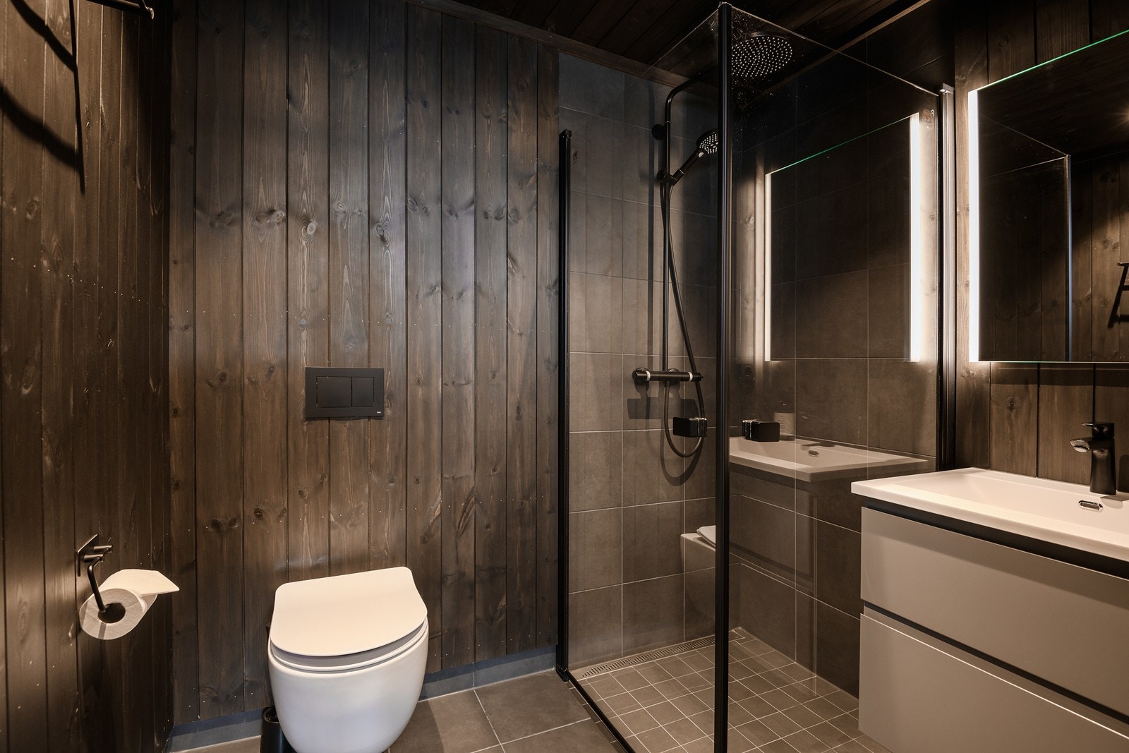 Lekkert flislagt en suite baderom med varme i gulv og panelkledde vegger Galleribilde