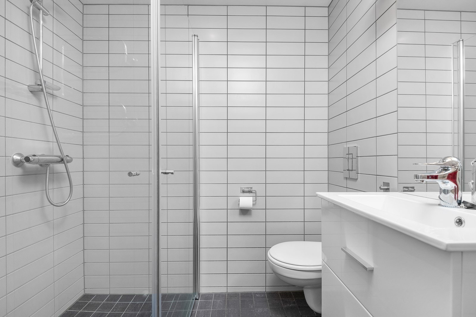 Det andre badet har dusj med glassvegger, wc og servantinnredning med skuffer for oppbevaring. Samme nøytrale og delikate stil som hovedbadet. Galleribilde