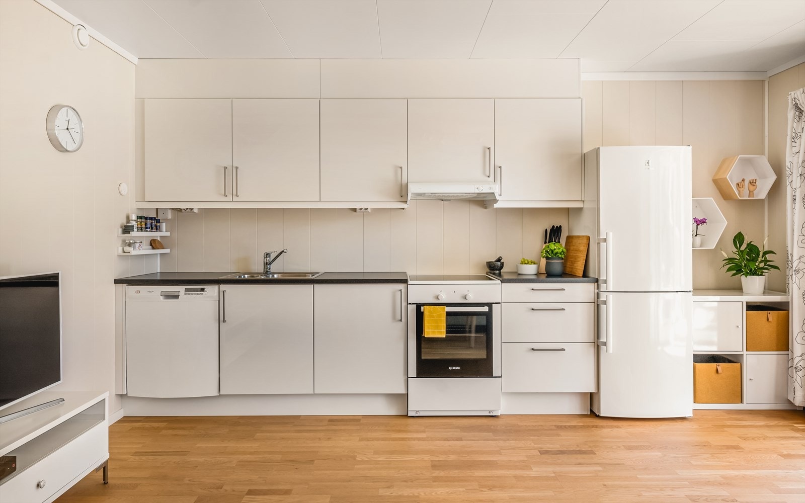 Åpen stue/kjøkkenløsning på til sammen 23 kvm som gjør det enkelt og sosialt. Norema kjøkkeninnredning med slette hvite fronter i høyglans. Laminat benkeplate, stål vaskekum, ventilator og opplegg for oppvaskmaskin. Det er montert komfyrvakt. Galleribilde