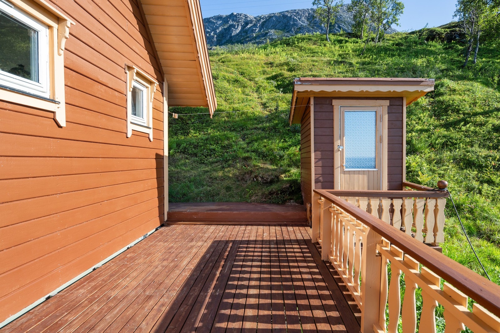 Terrasen går også rundt på baksiden av hytta. Til høyre ser du utstyrsbod. Galleribilde