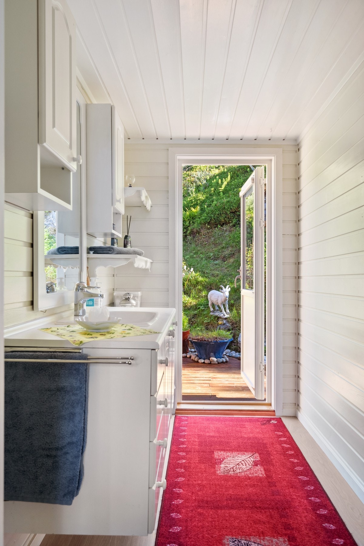 Baderoms-løsning med vask, og gjennomgang til baksiden av hytta. Galleribilde