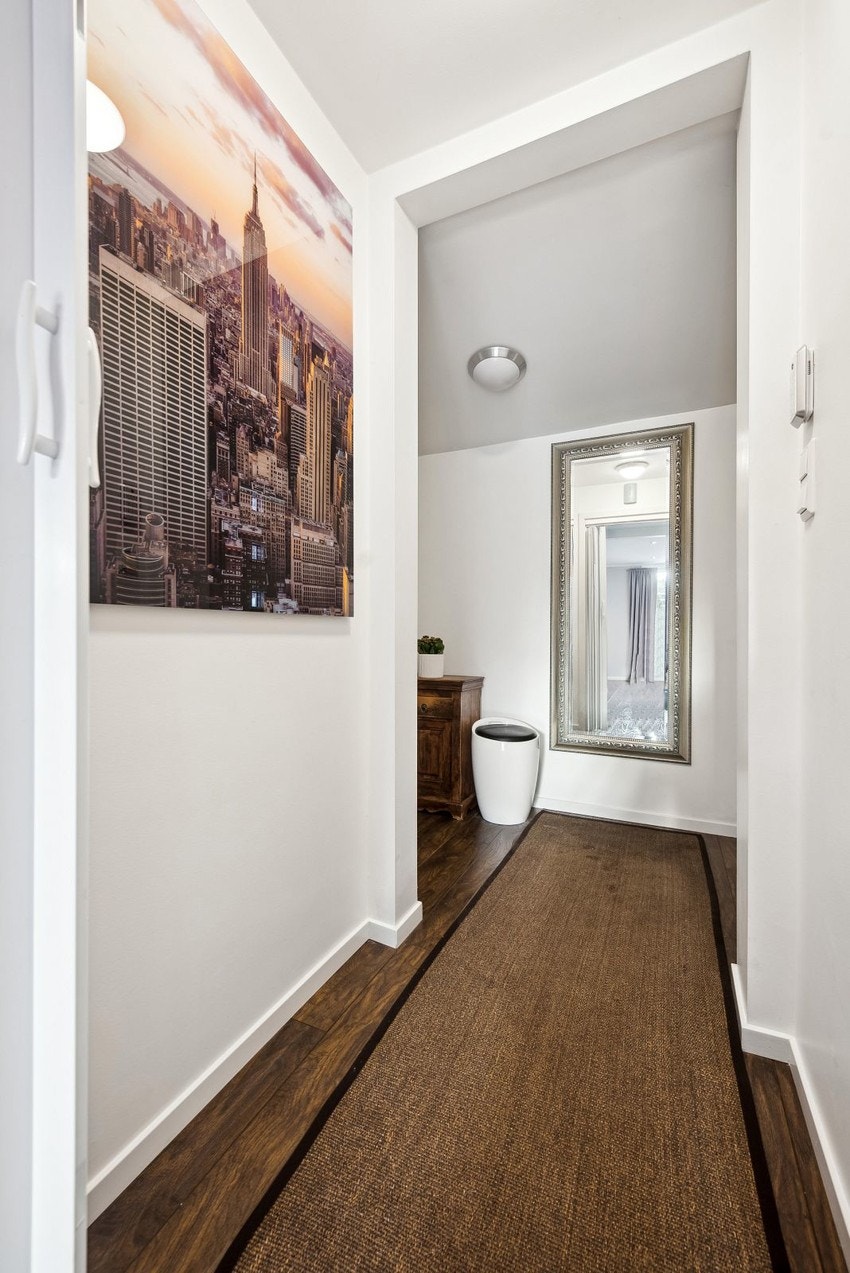 Vel inne i boligen møter vi en entré med skyvedørsgarderobe. Galleribilde