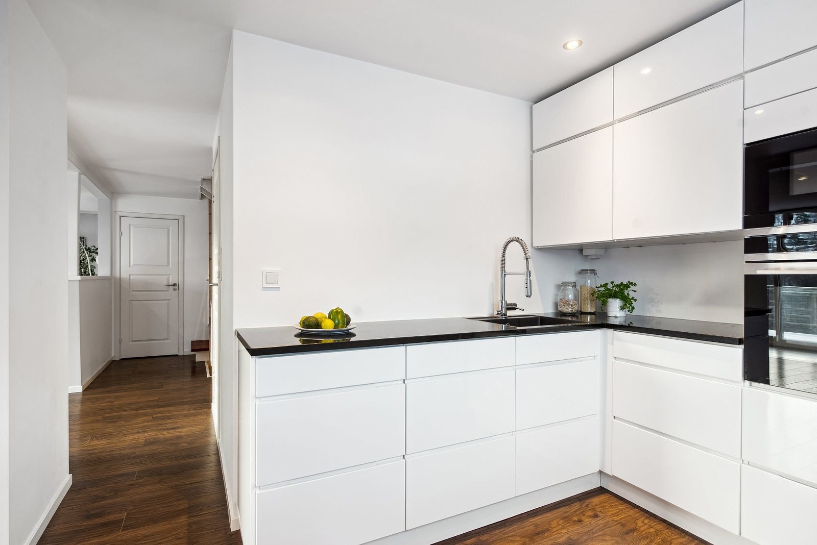 Kjøkkeninnredningen har slette fronter og benkeplate i stein, et materiale som egner seg godt til både matlaging og baking. Galleribilde