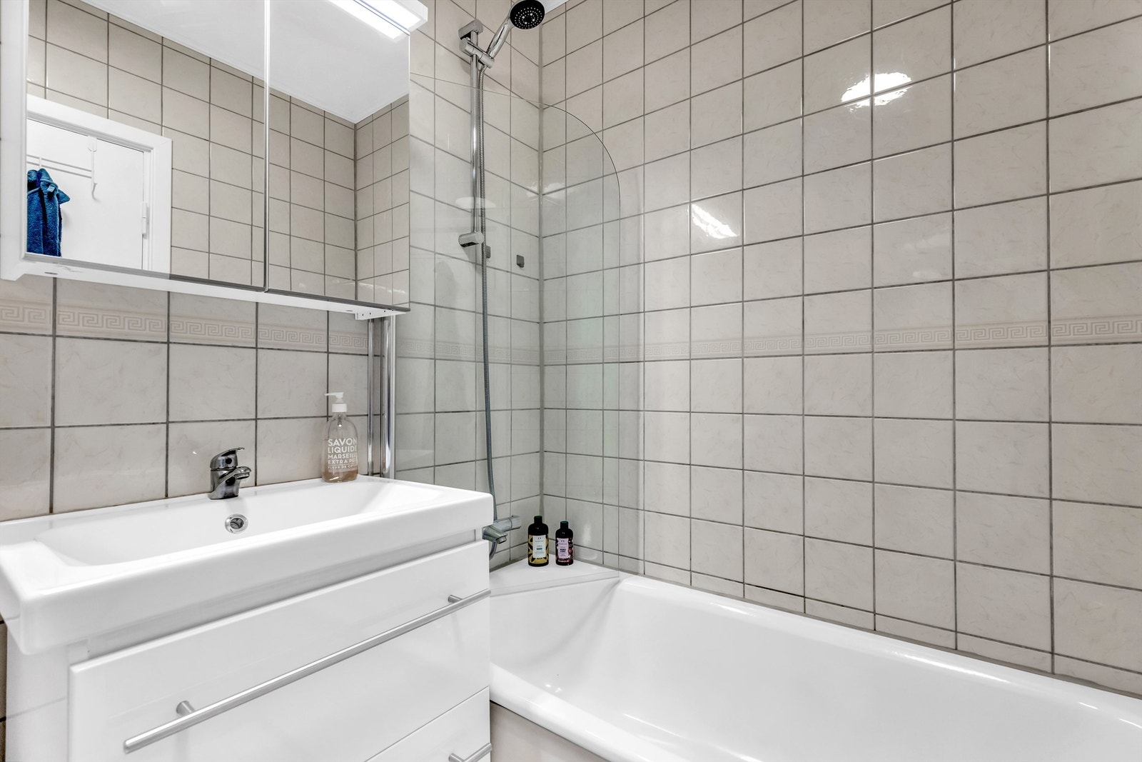 Flislagt bad/WC med badekar og opplegg vaskemaskin. Galleribilde