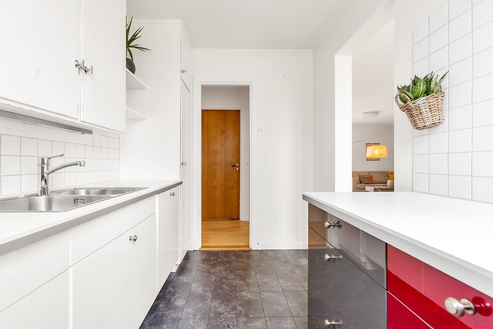 Kjøkkeninnredning med slette malte/høyglans fronter, laminat benkeplate og frittstående hvitevarer som komfyr og oppvaskmaskin. Galleribilde