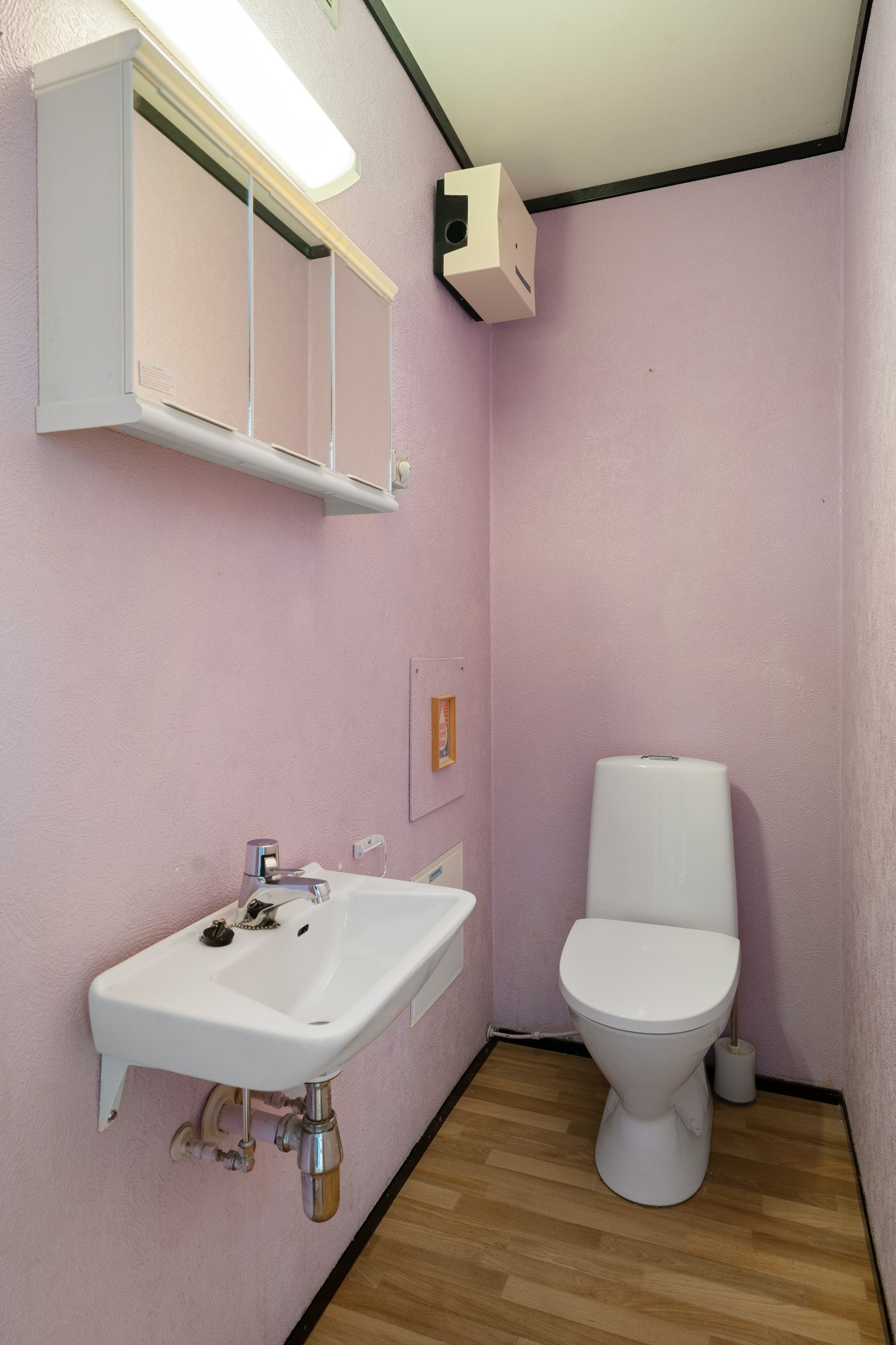 Toalettrom med wc og enkel servant. Galleribilde