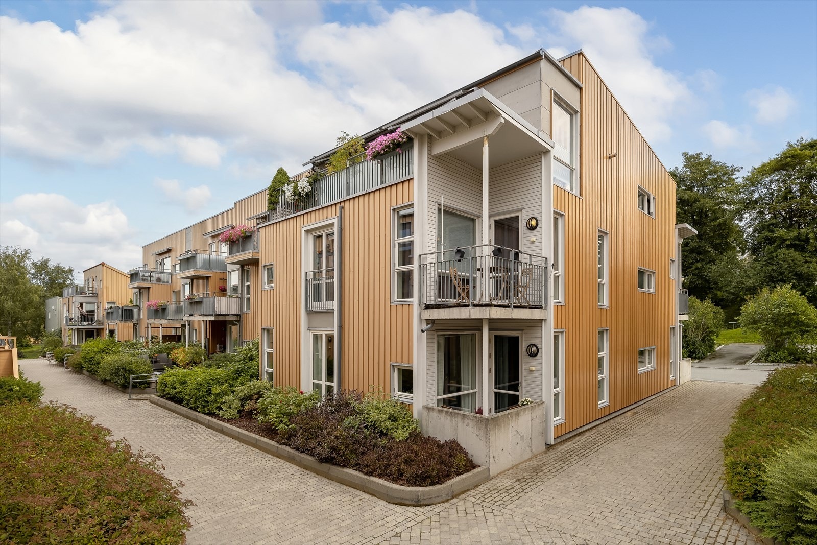 Leiligheten har god beliggenhet på hjørnet inn i feltet godt skjermet for trafikk. Det er opparbeidet bedd og busker utenfor leiligheten som gjør det hyggelig og hindrer innsyn. Galleribilde