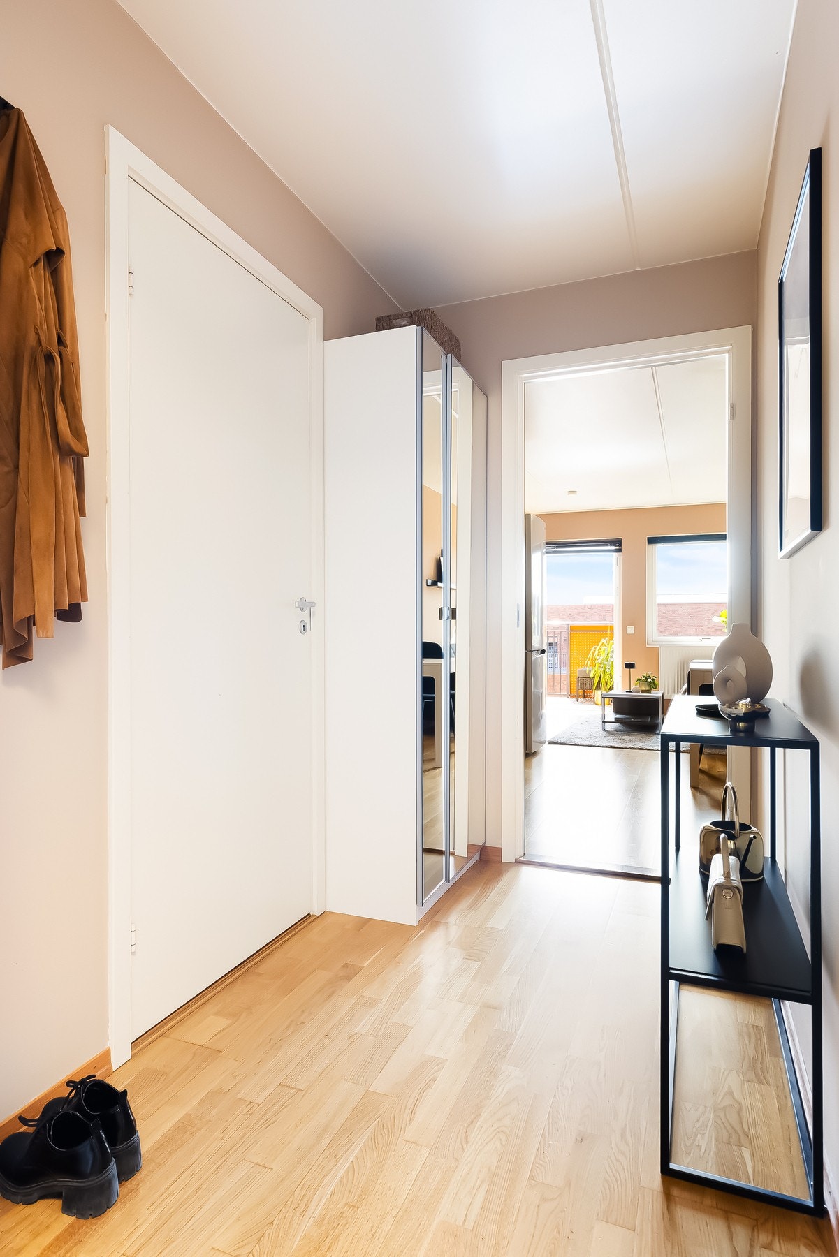 Lys entré som gir et godt førsteinntrykk av boligen. Her er det plass til oppheng av yttertøy og plassering av sko. Galleribilde