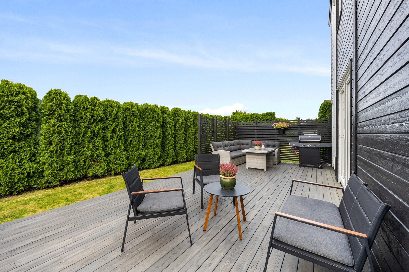 Boligen har fine utearealer med hage, terrasseplatting på begge sider av boligen og balkong Galleribilde