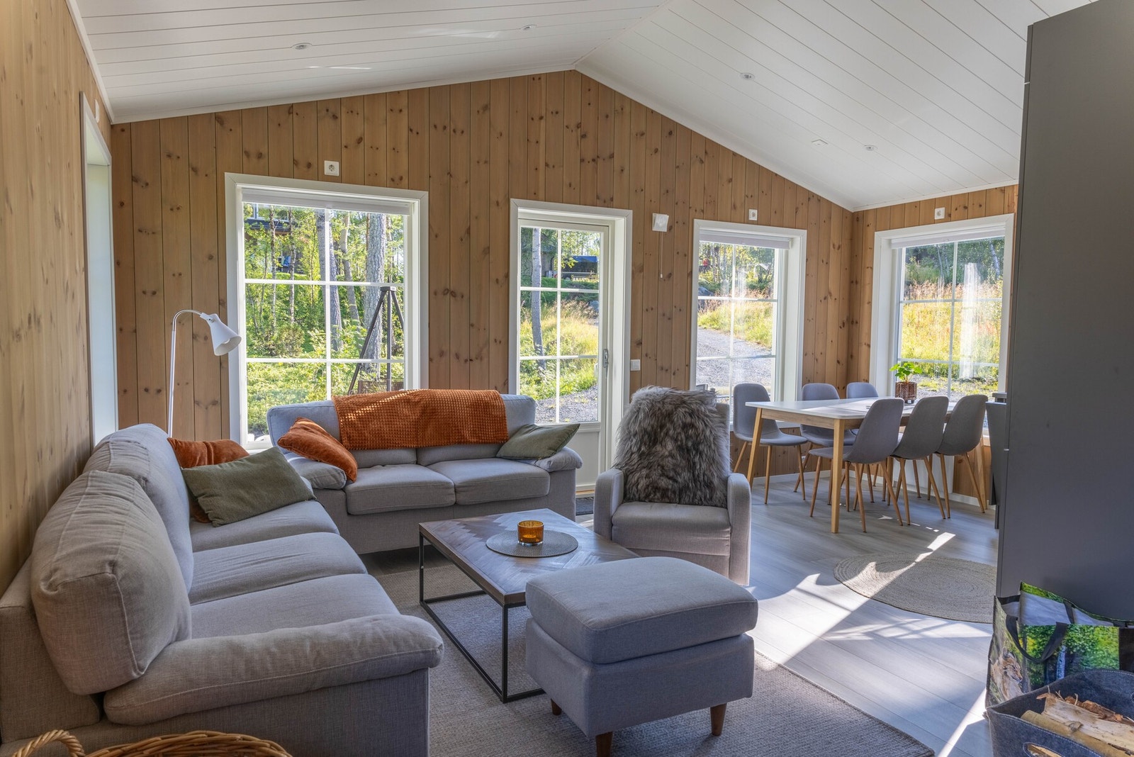 Stuen oppleves som lun og koselig med trepanel på vegger og i himling Galleribilde