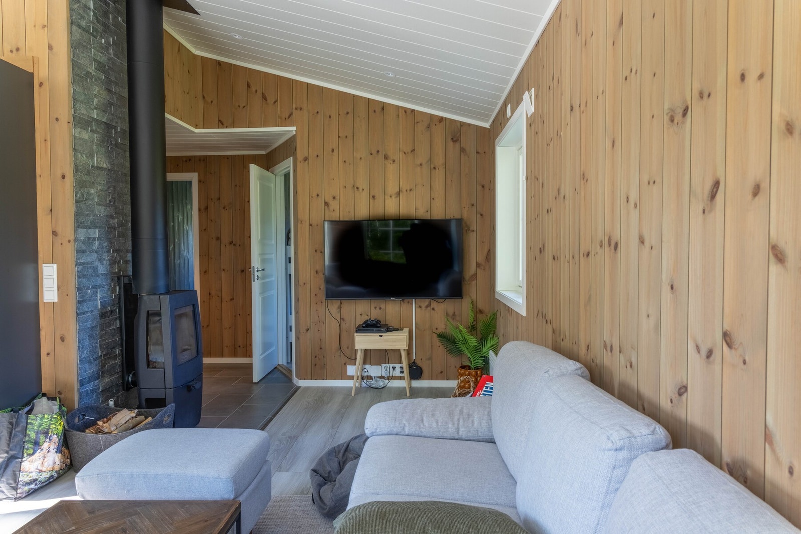 Sentralt i hytten er det plassert en vedovn Galleribilde