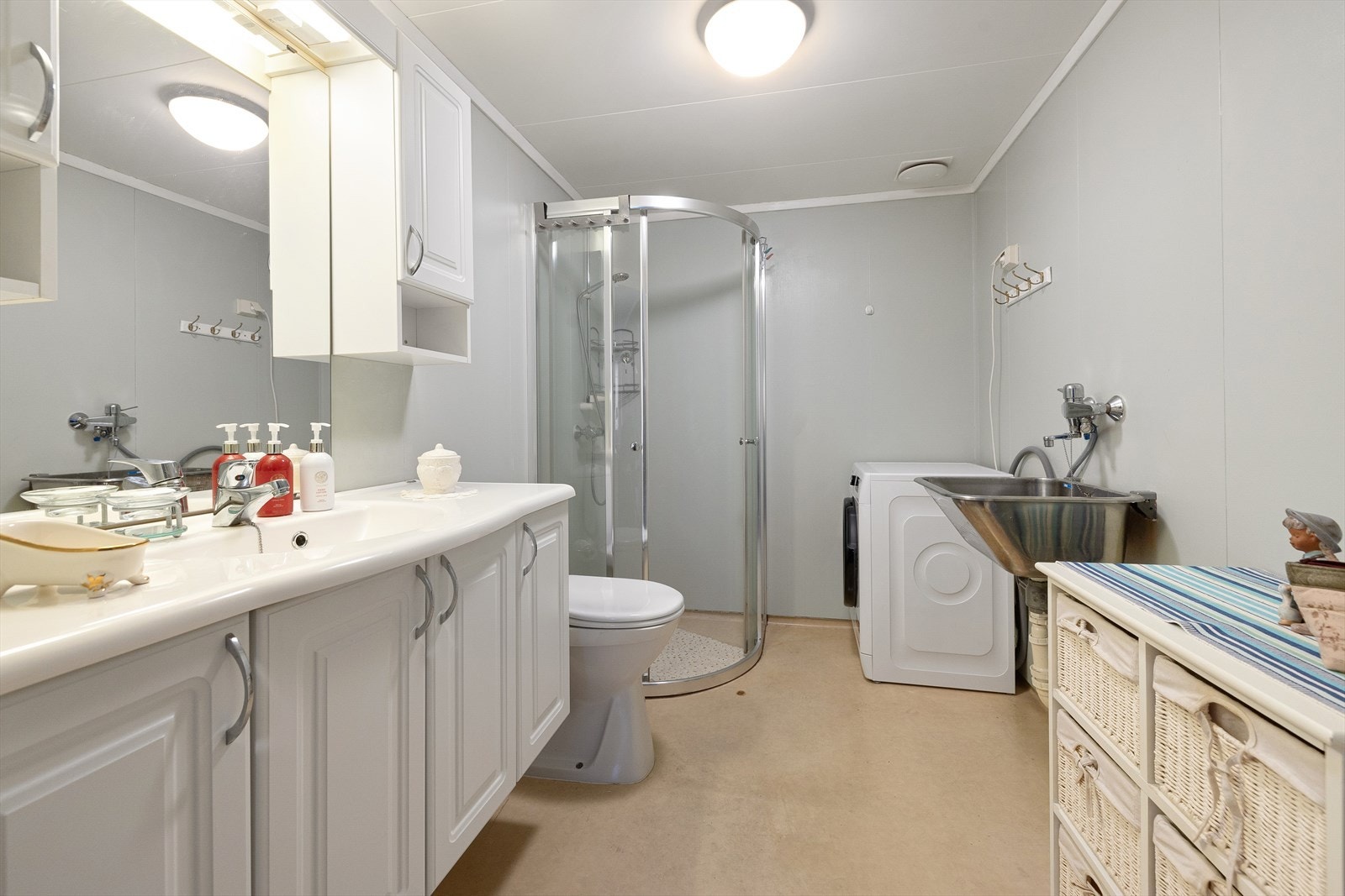 Badet er et kombinert bad/vaskerom, utstyrt med skyllekum og opplegg for vaskemaskin. Galleribilde