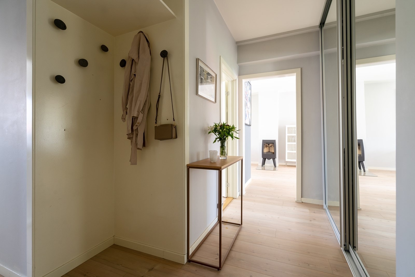 Entréen er romslig og åpen med mye lagringsplass i en stor skyvedørsgarderobe med speilfronter. Galleribilde
