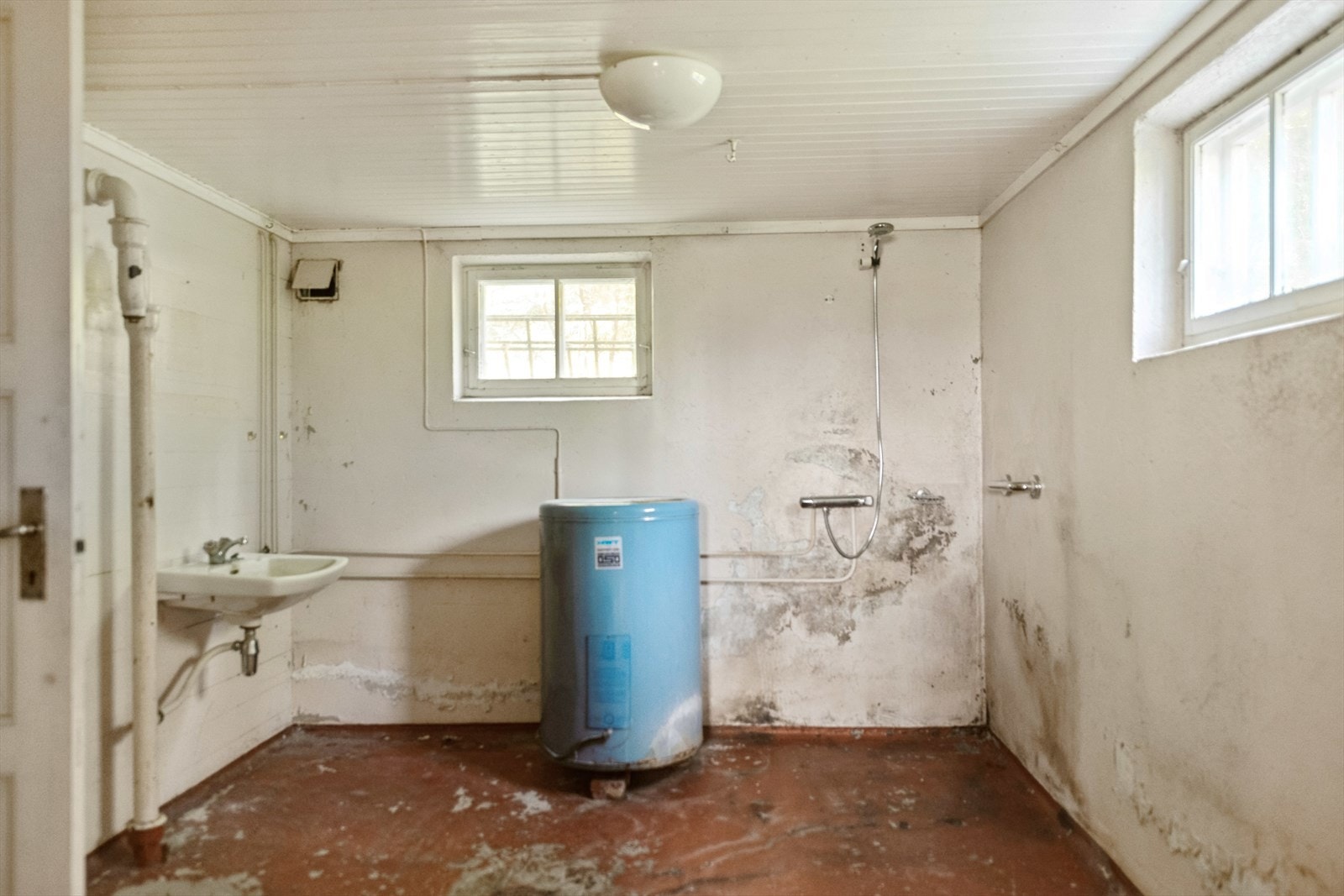 Gammel vaskekjeller med enkelt dusjgarnityr. Galleribilde