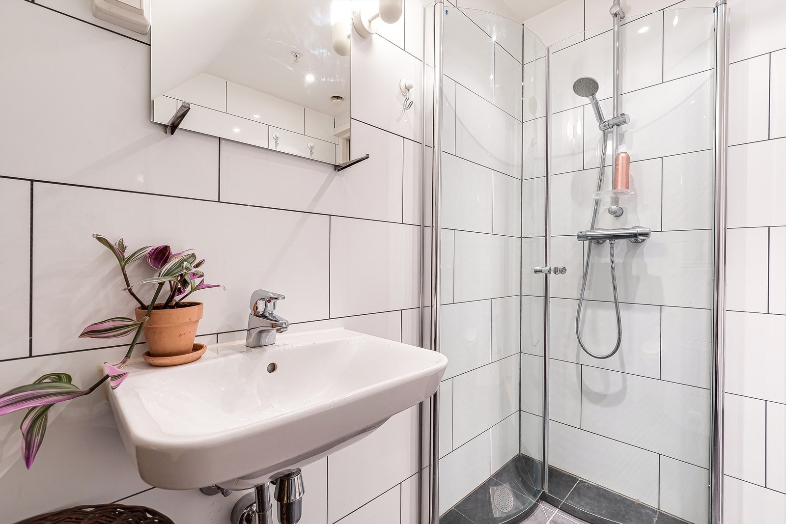 Badet er fra byggeår 2015, med tidløse fliser i lys utførelse. Her finner du dusj på gulv med dører i herdet glass, veggfestet klosett med innebygget sisterne, servant og opplegg for vaskemaskin. Galleribilde
