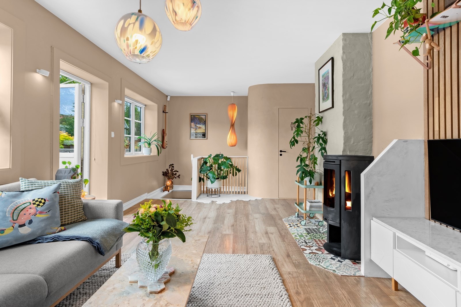 Stuen har store og flotte vindusflater som slipper inn godt med naturlig lys. Fliser foran peisen er fra Far-Far Fliser Galleribilde