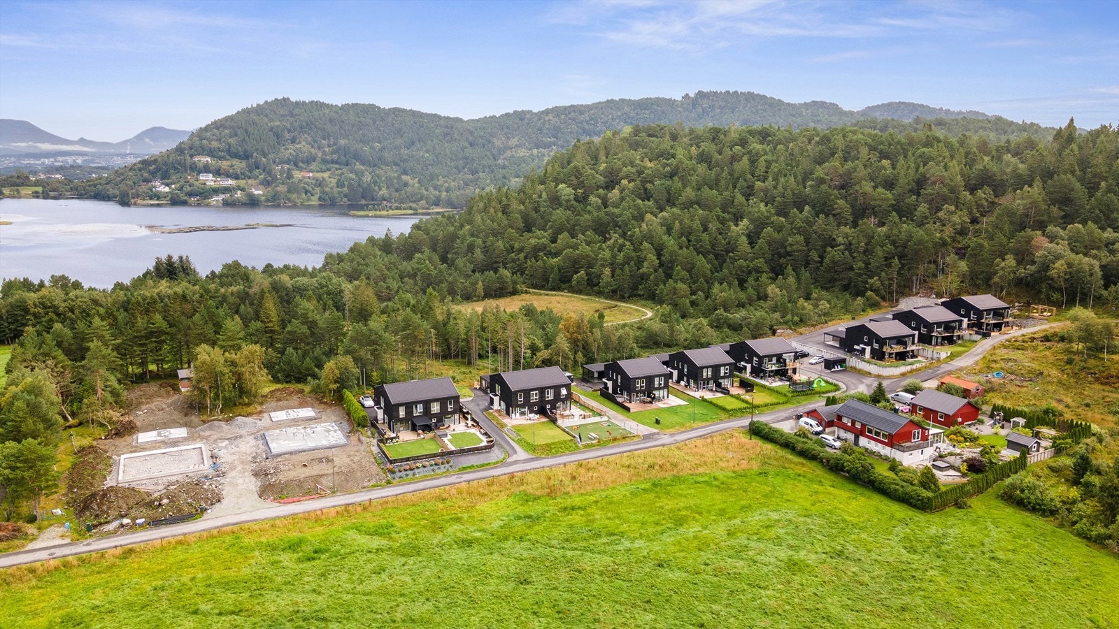 Dronebilde av eiendommen og nærområdet sett fra vest med Mauseidvannet i bakgrunnen Galleribilde