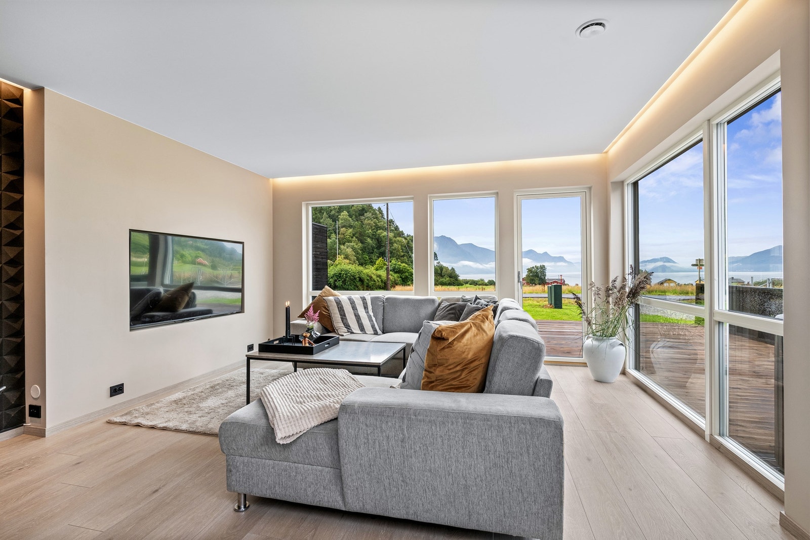 Stuen har lyse overflater og godt med naturlig lysinnslipp fra store vindusflater Galleribilde