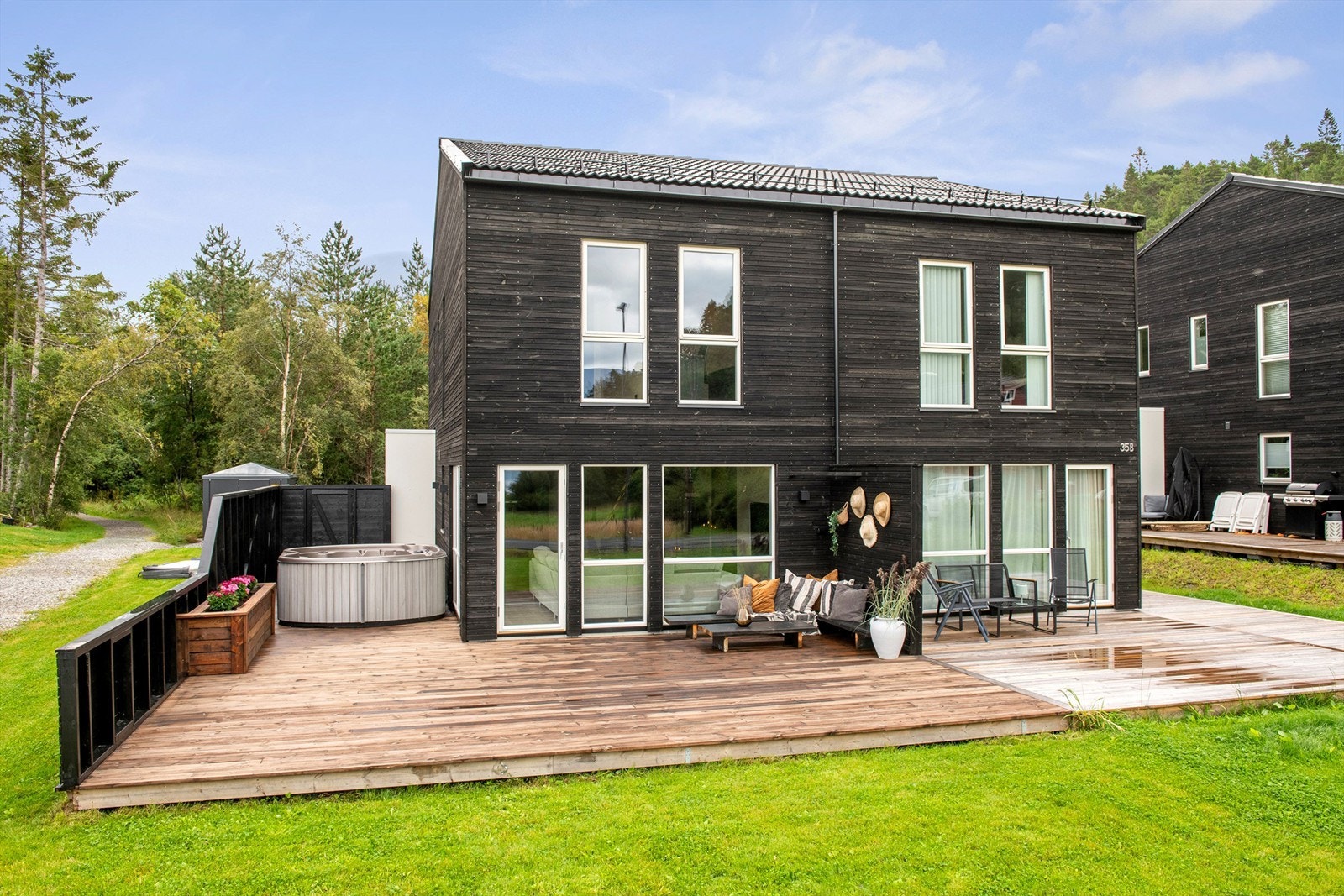 Stor flott terrasse skjermet med levegg mot nabo og gjerde mot gangvei Galleribilde