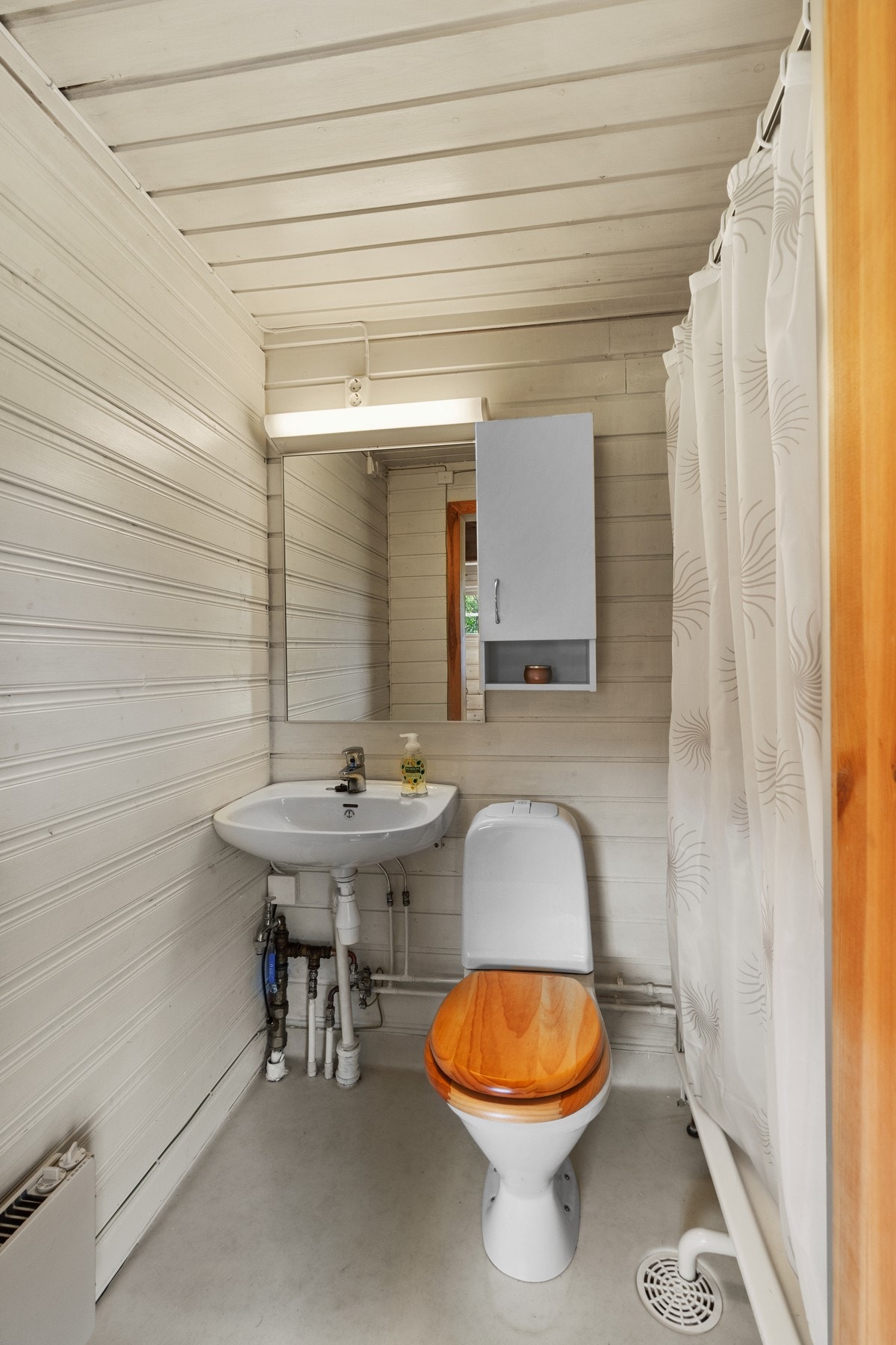 Badet har et praktisk dusjhjørne og toalett. Galleribilde