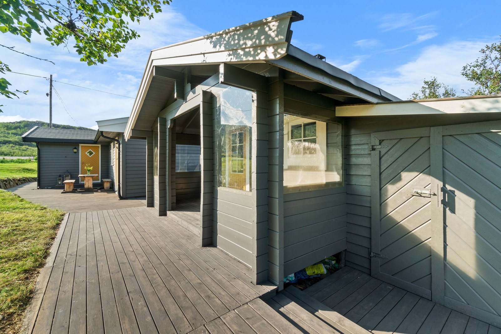 Platten sammenkobler hytta, badstuhus og vedbod. På sommerstid kan man fint gå tørrskodd mellom bygningene. Galleribilde