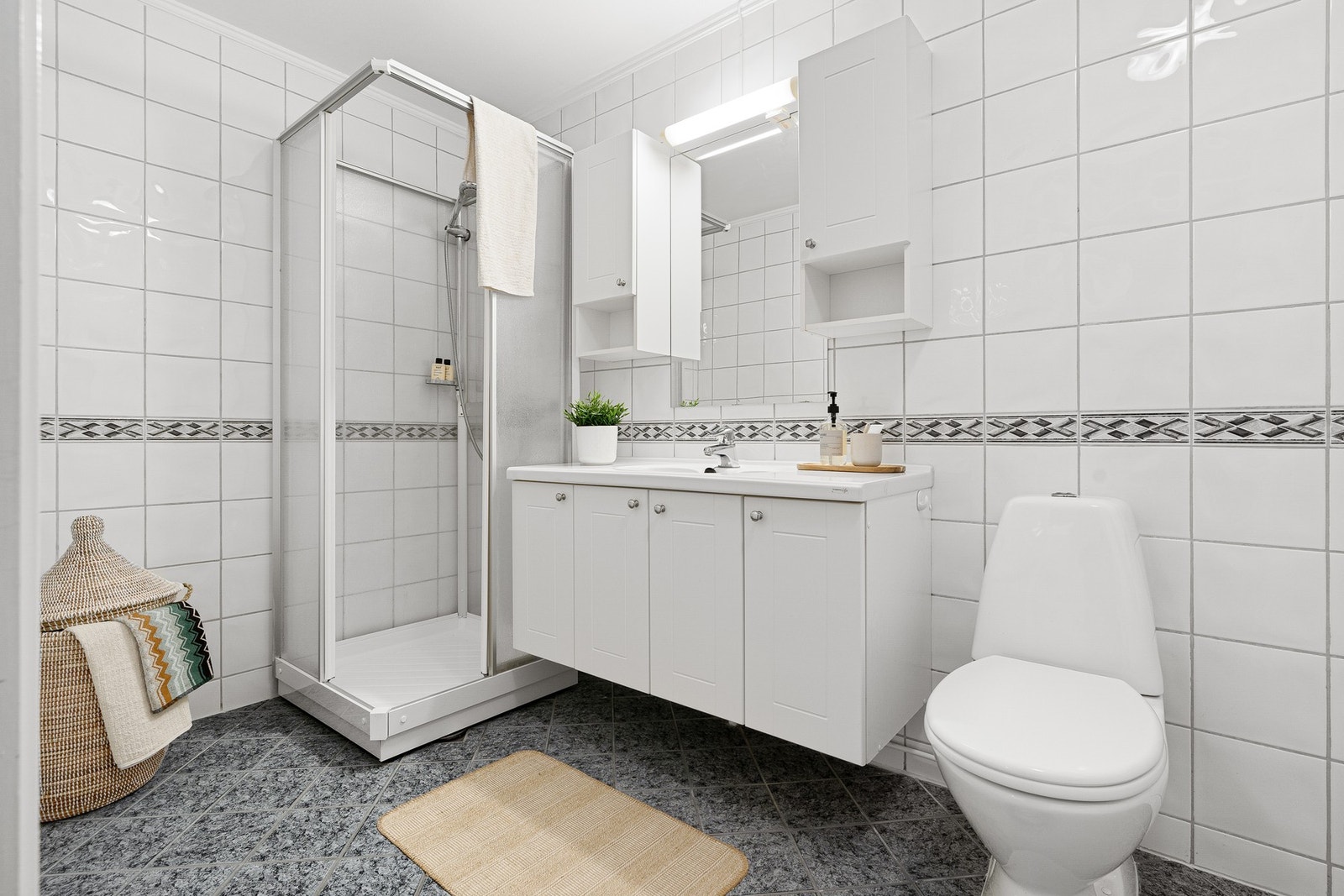 Flislagt baderom på 5,3 kvm med dusjkabinett, lys innredning og toalett. Galleribilde