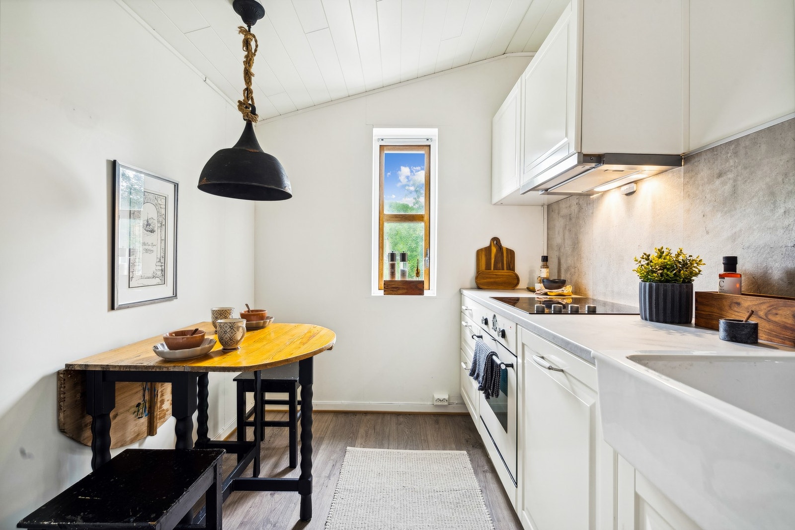 Ned et par trinn har du dette lyse, fine kjøkkenet med skråtak i ståhøyde. Her er det integrert stekeovn, keramisk platetopp og oppvaskmaskin. Galleribilde