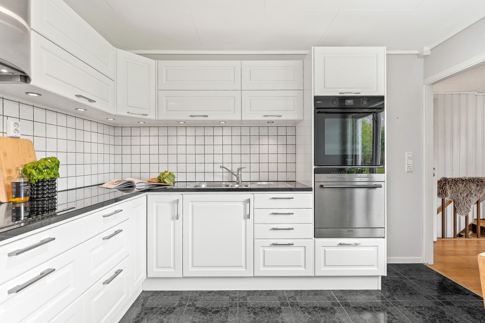 Nydelig og tidsriktig kjøkken med profilerte fronter og benkeplate i stein. Det er også lagt opp spotter og fliser på vegg mellom benkeplate. Galleribilde