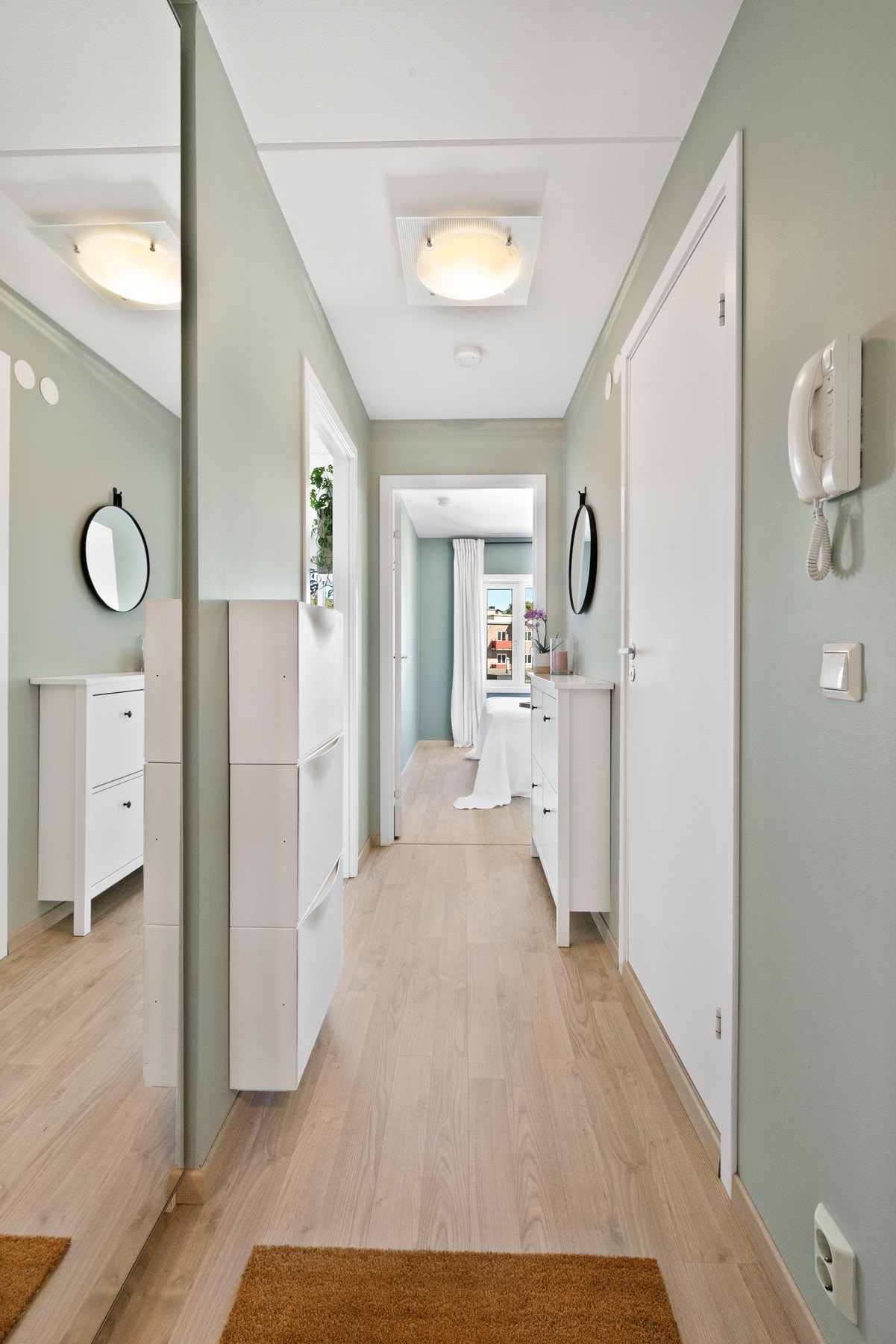 Lys og innbydende entré innredet med stort garderobeskap med speilfronter. Galleribilde
