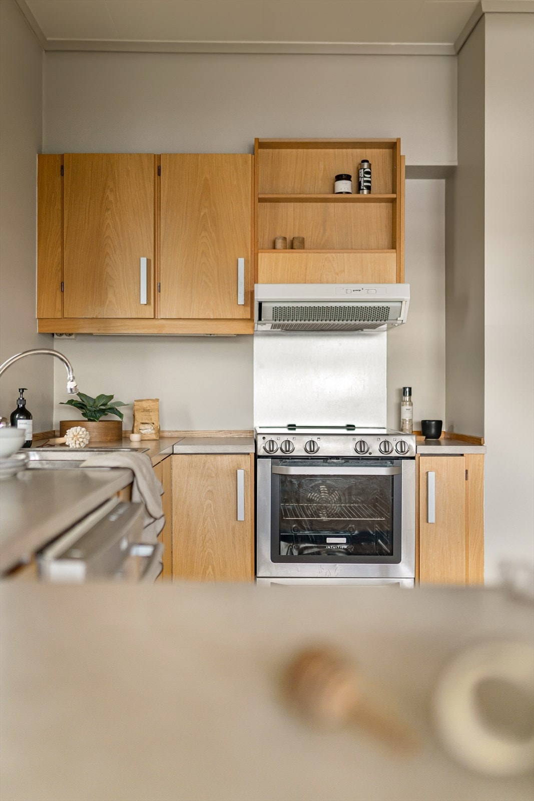 Kjøkkeninnredning med slette fronter hvor enkelte overskap har glassfronter. Galleribilde