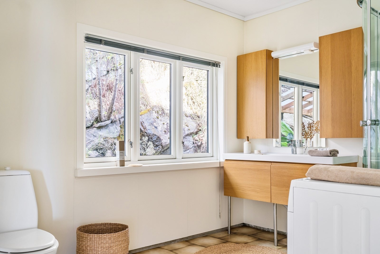 Badet i 1.etasje har fliser på gulv og baderomsplater på veggene. Galleribilde