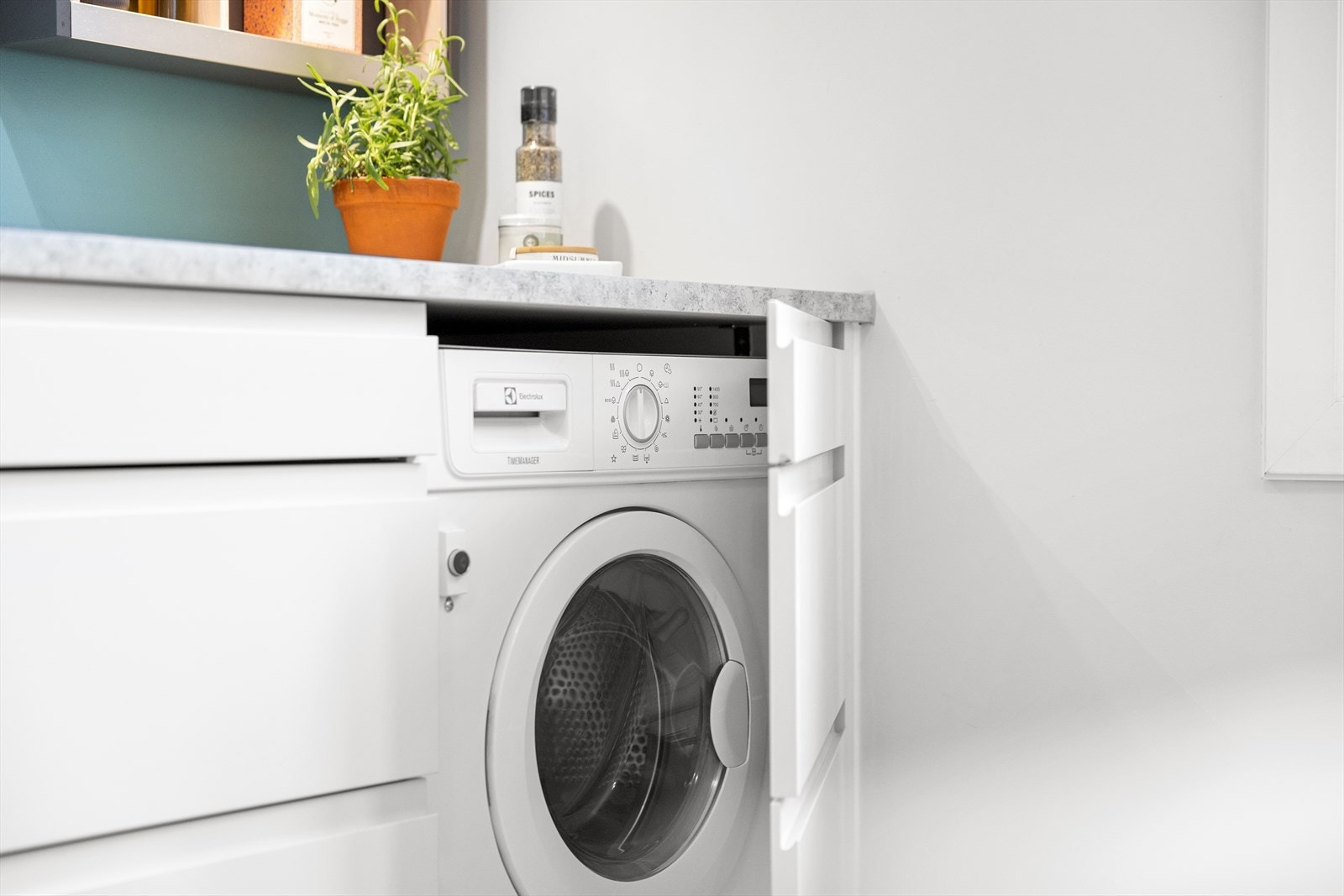 Kjøkkenet har en kombinert vaskemaskin og tørketrommel installert, skjult bak en front. Galleribilde