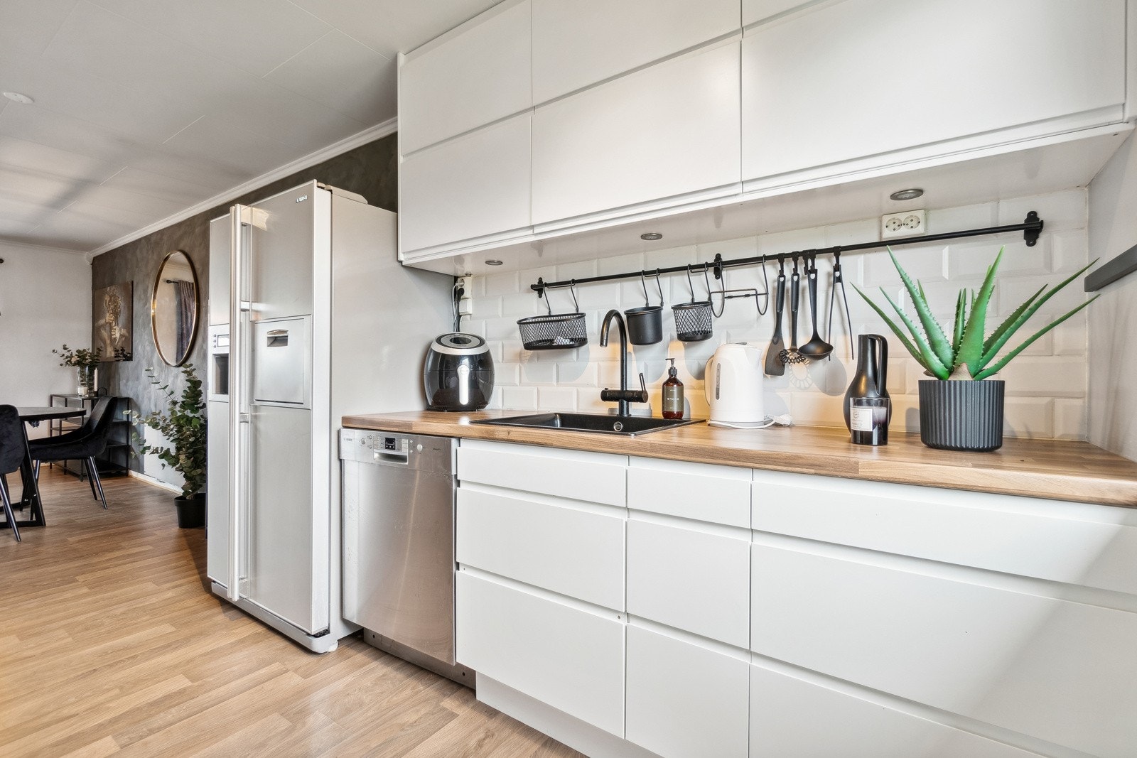 Kjøkkeninnredningen strekker seg over 2 vegger og har integrerte hvitevarer som platetopp, stekeovn, mikrobølgeovn, oppvaskmaskin og kaffemaskin. Galleribilde