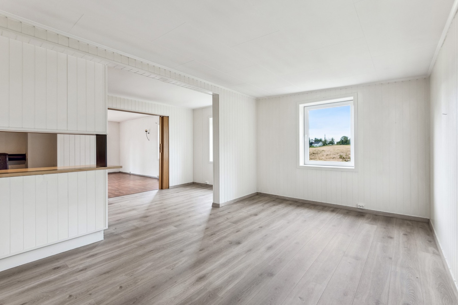 Spisestuen er romslig. Mellom kjøkkenet, spisestuen og stuen har man store åpninger som gir godt med gjennomlys. Galleribilde