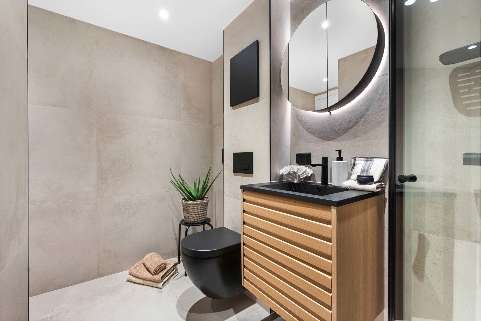 Videre finner du et pent og moderne bad, renovert i 2024. Badet har pene fliser og stilige detaljer i sort på innredningen, samt varmekabler i gulv og downlights i himling Galleribilde