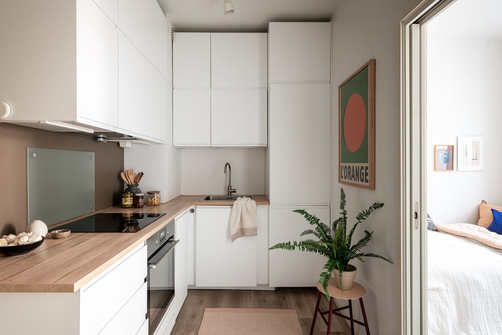 Stilrent kjøkken med hvite fronter og laminert benkeplate. Plassen er godt utnyttet med skap- og benkeplass. Galleribilde